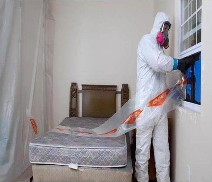 SERVPRO crew member in PPE cleaning a biohazard
